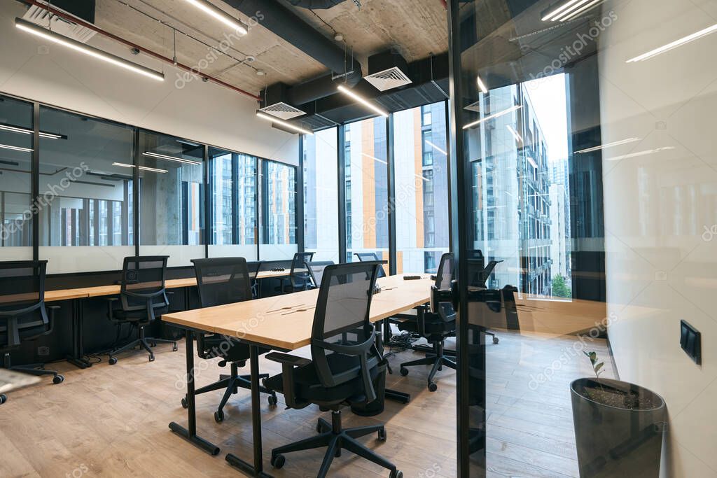 Spazio di coworking con postazioni ordinate e aree comuni pulite