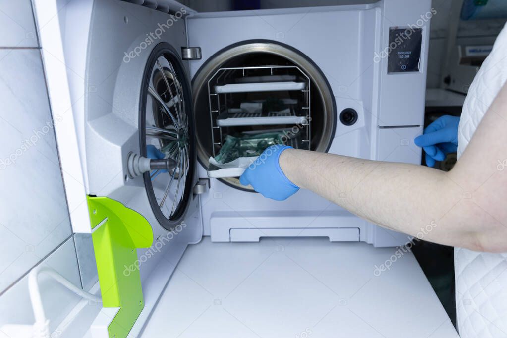 Operatore che sanifica le superfici di contatto in un ambiente interno
